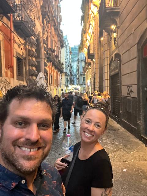 Couple standing on a street with historic buildings.