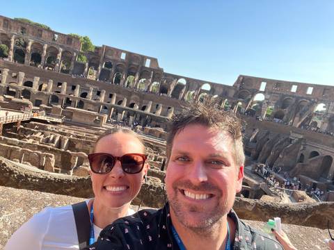 Two people upside-down in front of an ancient structure.