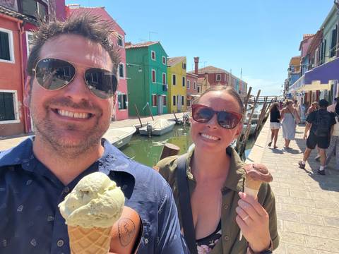 Upside-down group photo in front of colorful buildings.