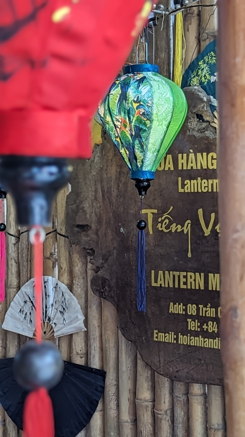 Hanging lanterns in vibrant colors with a wooden wall background.