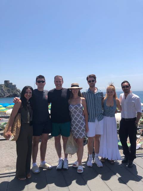 Group of people posing together outdoors with a scenic view.