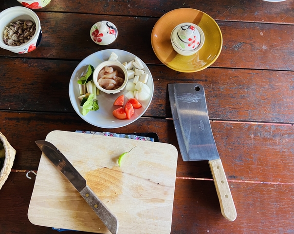 Ingredients and utensils on a wooden table for cooking.
