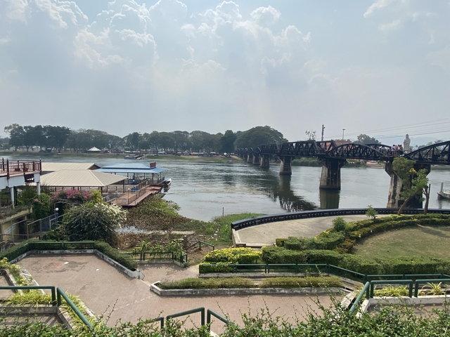 View of a river with a historic bridge under a hazy sky.