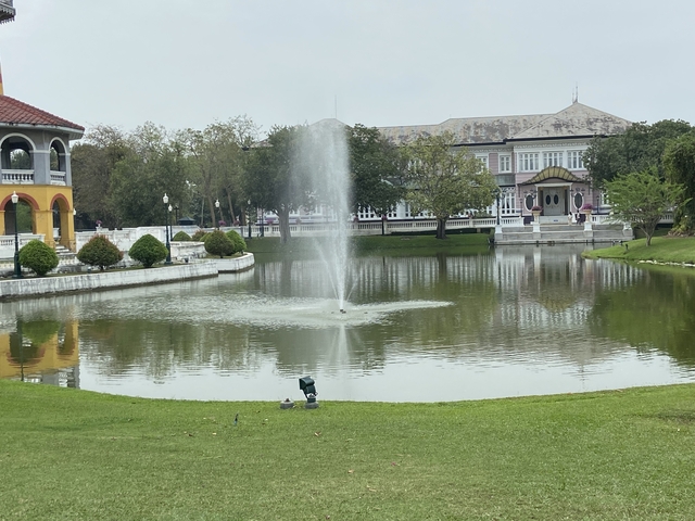 Fountain in a peaceful garden setting with buildings.