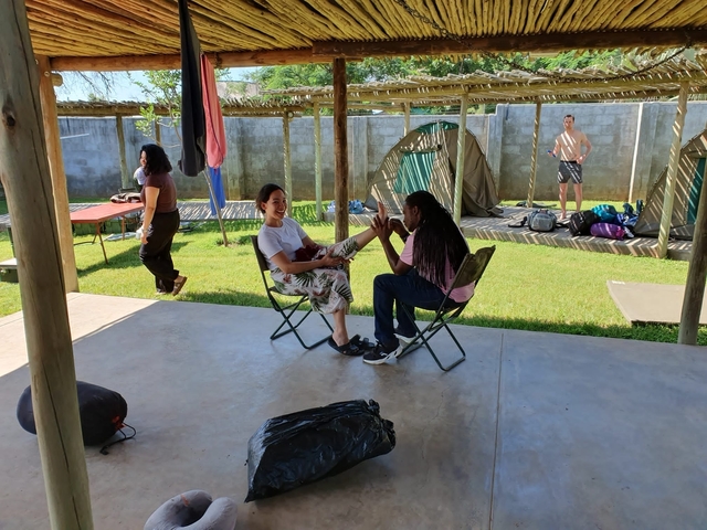 People sitting and interacting in a campsite.