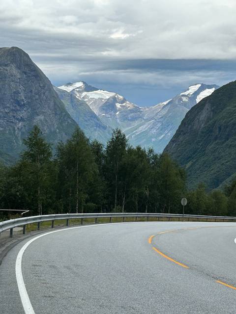 Curving road with mountain views in the background.