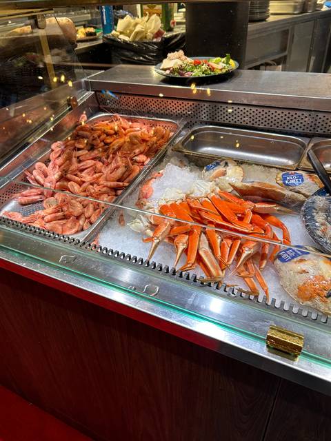 Display of seafood including crabs and shrimps on ice.