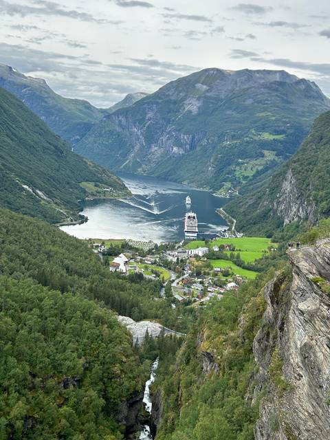 Panoramic view of a coastal village with a large cruise ship.