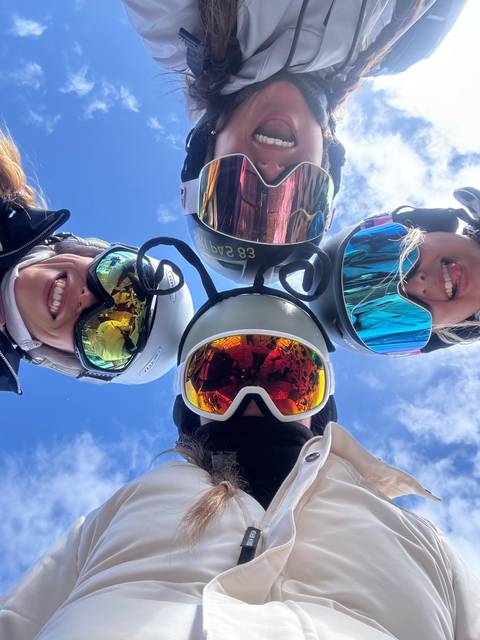 Group selfie with ski helmets and goggles.