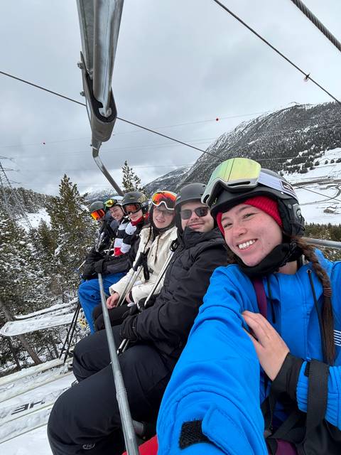Group of people on a ski lift taking a selfie.