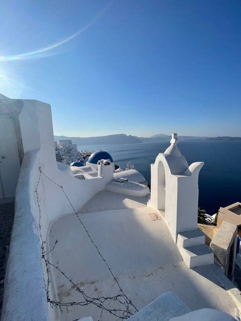 Iconic blue dome and white structures overlooking the sea.