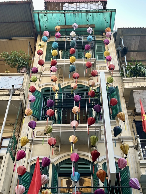 A building facade decorated with colorful hanging lanterns.