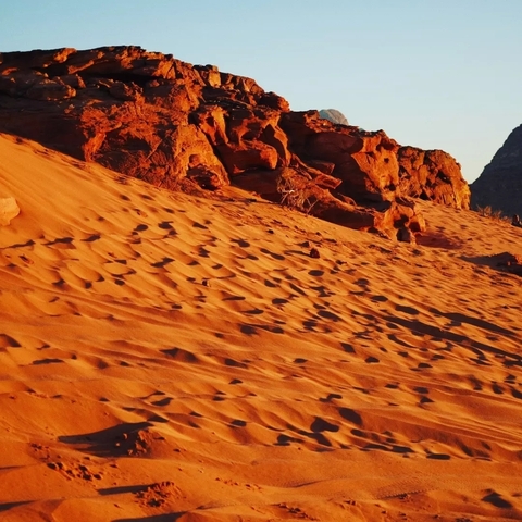 Sand dunes and rocky formations in the desert.