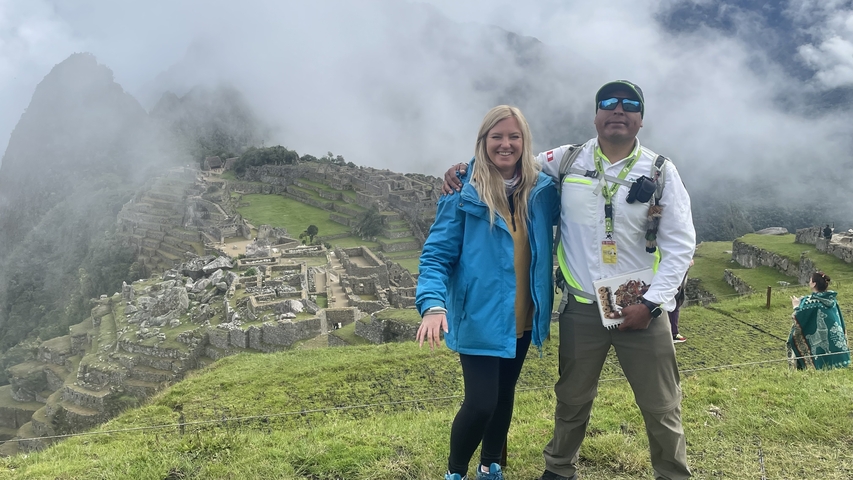 Two people posing with a view of Machu Picchu in the background.