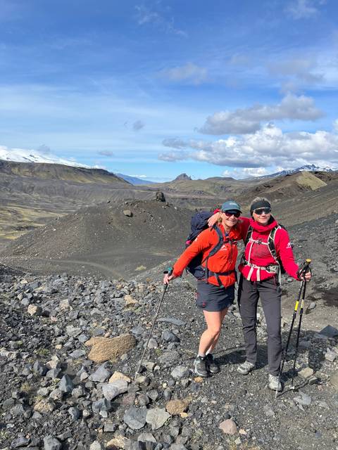 Two people hiking on rocky terrain.