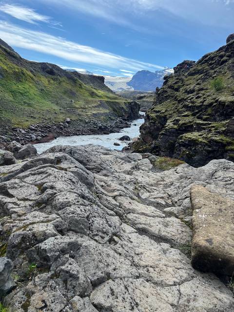 Mountainous landscape with cliffs and river.