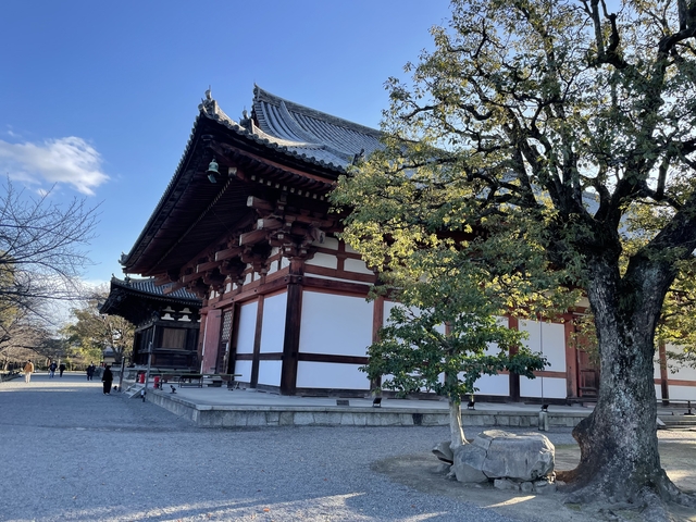 Traditional wooden temple with ornate details and trees.