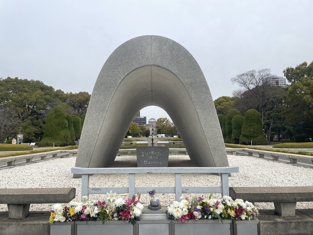 Peace Memorial Park structure with trees and buildings in the background.