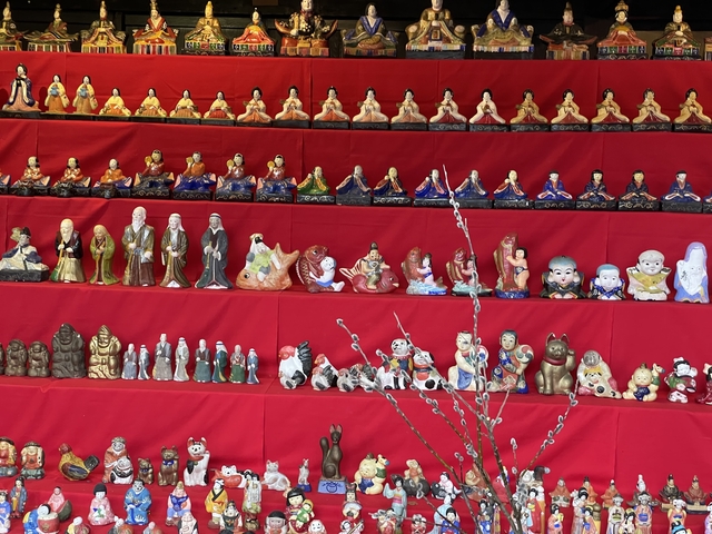 Display of decorative figurines on red shelves.