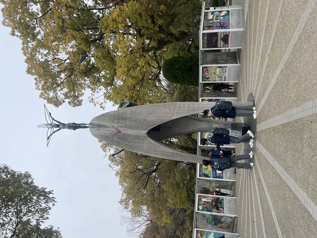 Statue in Hiroshima Peace Memorial Park with people nearby.