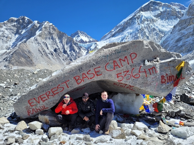 Hikers at Everest Base Camp with snowy mountains in the background.