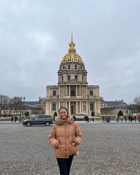 Person standing in front of a historical building.