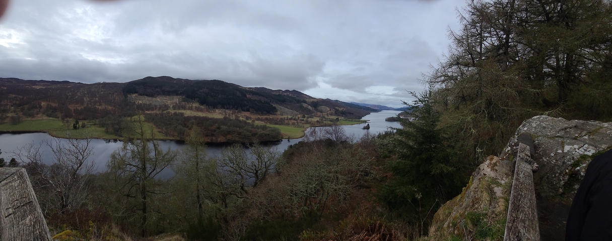 Panoramic view of a lake and forested hills.