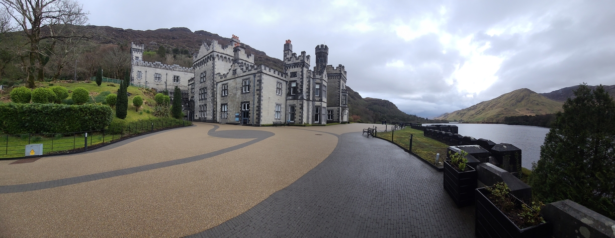 Castle next to a lake in a mountainous area.