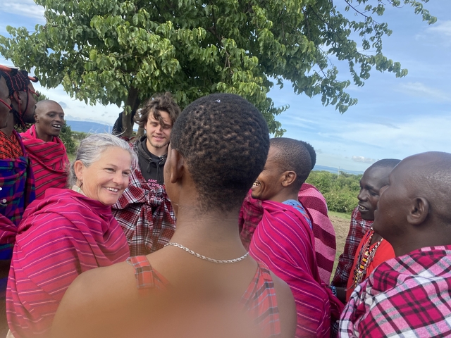 Group of people interacting with Maasai tribe members.