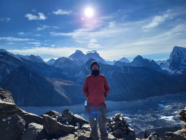 Person with a stunning view of snowy mountain peaks.
