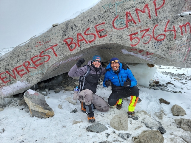 Two people posing under the Everest Base Camp sign.