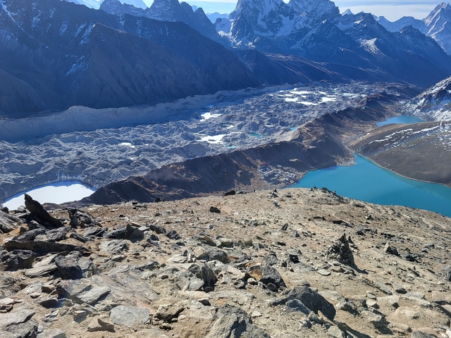 Expansive mountain landscape with turquoise lakes and rugged terrain.