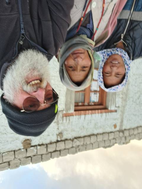 Group selfie with two locals and a traveler.