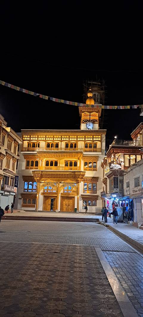 Night time view of a bustling street with shops.