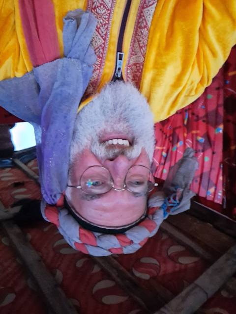 Man in traditional attire smiling at camera.