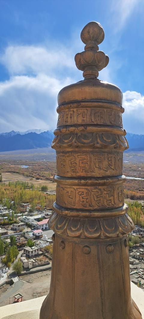 Close-up of ornate metallic structure with town below.