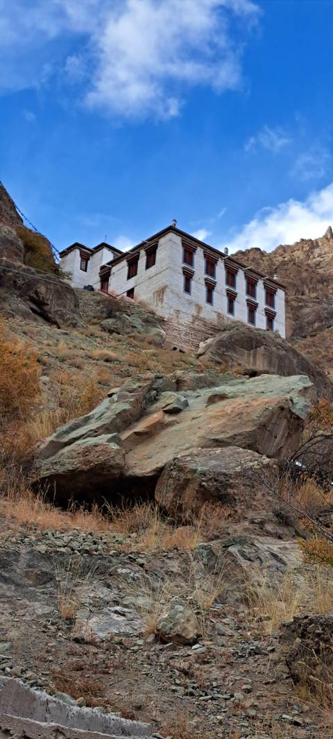 A building on a rocky cliff under a blue sky.