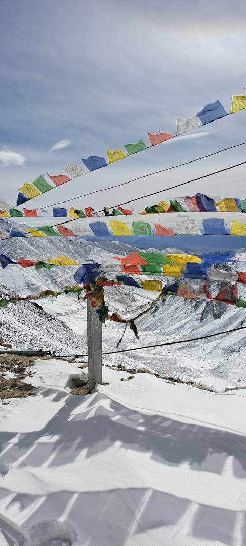 Colorful prayer flags against a snowy landscape.