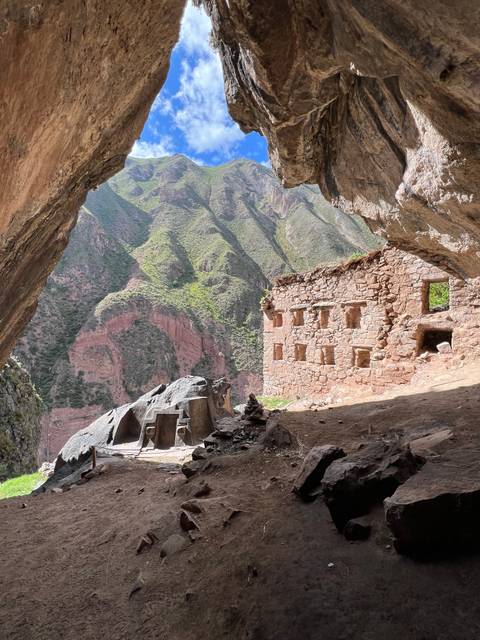 View from within a ruin overlooking a lush valley.