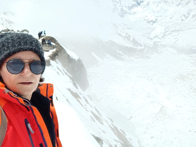 Person taking a selfie with a snowy landscape in the background.