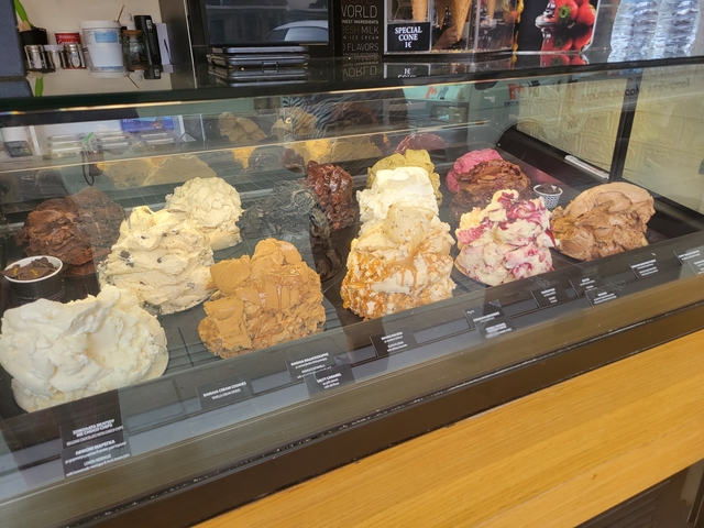 Display of various ice cream flavors in a glass counter.