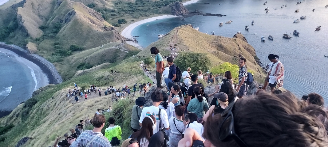 Hikers traversing a ridge with scenic view.