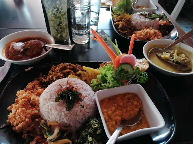 Assorted Sri Lankan dishes with rice, curry, and vegetables.