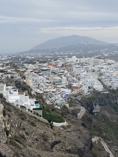View of a Greek island town with white buildings on a hillside.
