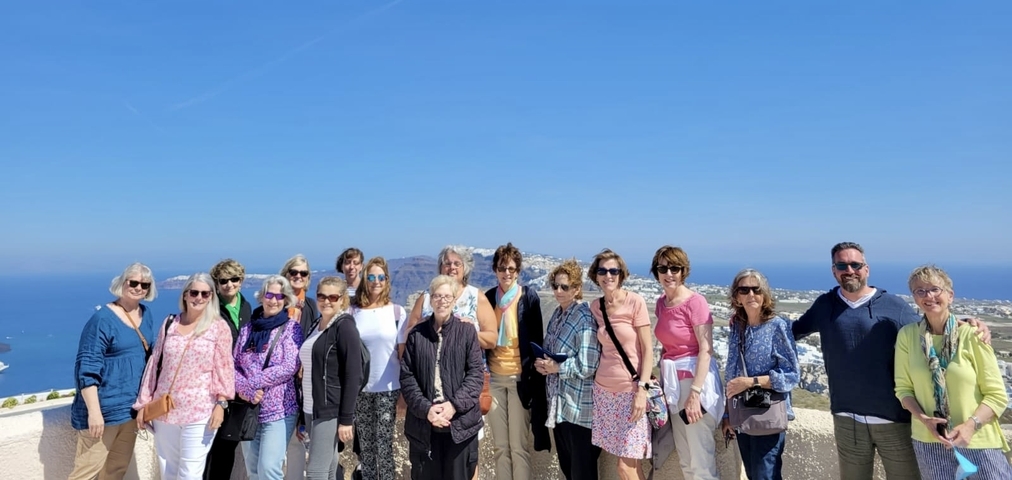 Group of people posing with a scenic backdrop.