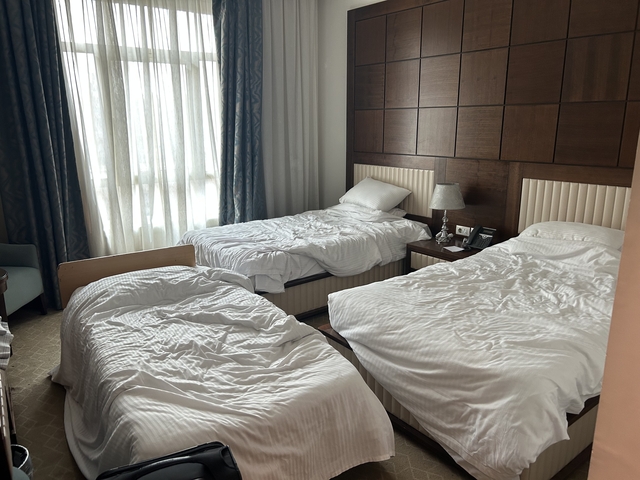 Interior of a hotel room with unmade beds.