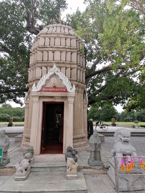 Small Buddhist shrine in a garden setting.