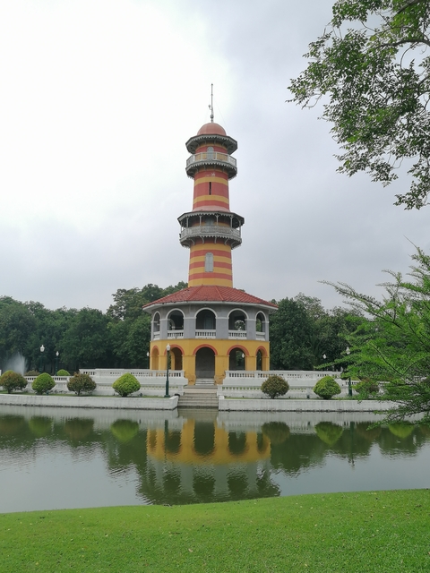 Colorful striped tower in a park.