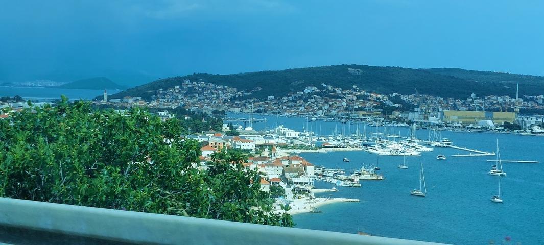 Marina filled with boats near a coastal town.