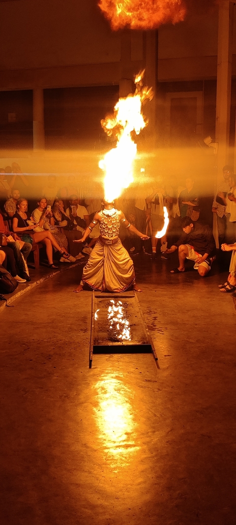 Cultural performance with fire dancing surrounded by spectators.